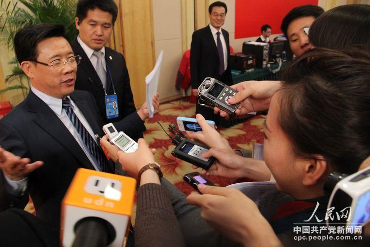 三一重工股份有限公司董事長梁穩(wěn)根會后被媒體記者“圍堵”。（人民網(wǎng)記者 毛雷 攝）