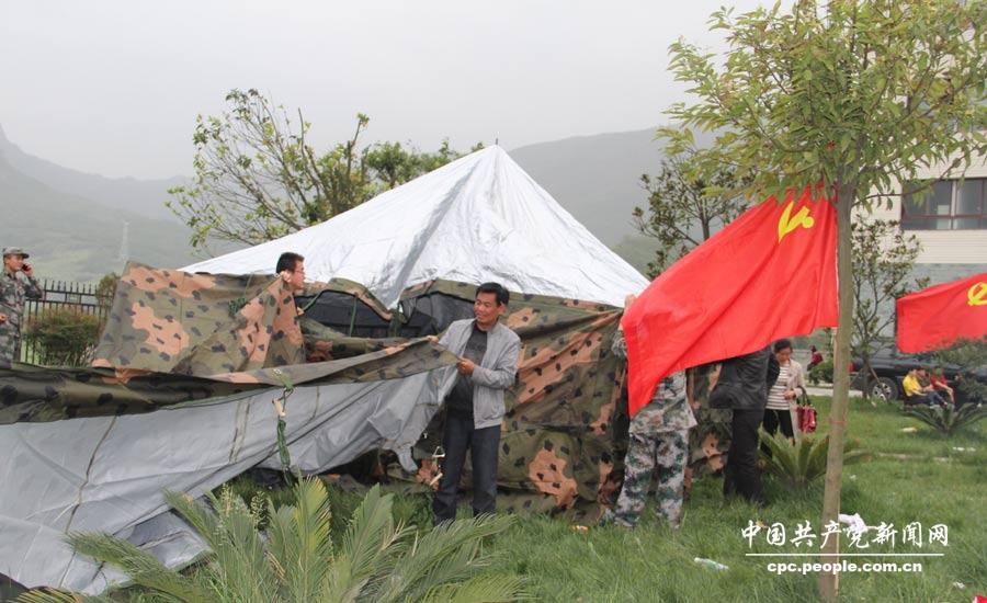 黨員干部在龍門鄉(xiāng)安置點(diǎn)幫助群眾搭建帳篷