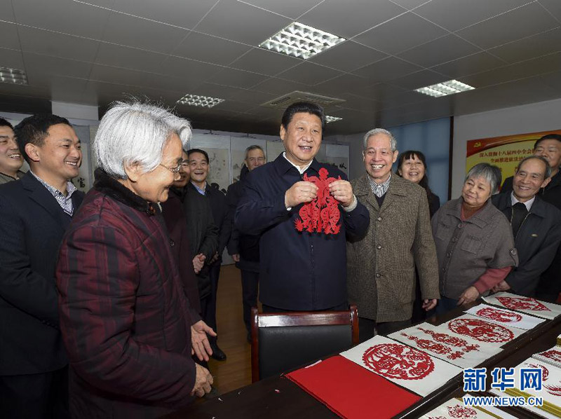 這是15日上午，習(xí)近平在西安市雁塔區(qū)電子城街道二〇五所社區(qū)服務(wù)中心，拿起一幅“三陽(yáng)開(kāi)泰”剪紙，祝願(yuàn)全國(guó)各族人民新春愉快、羊年大吉，生活喜氣洋洋，事業(yè)蒸蒸日上。新華社記者 李學(xué)仁 攝