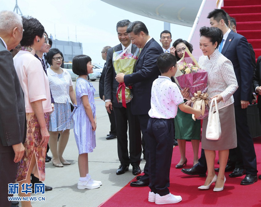這是習近平和夫人彭麗媛在舷梯旁接受兩名香港少年敬獻鮮花。新華社記者 蘭紅光 攝