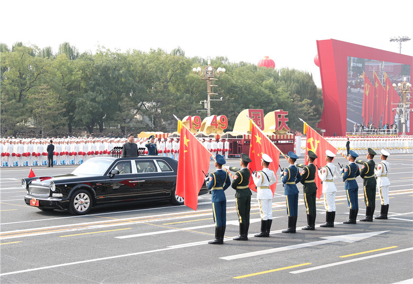 10月1日，慶祝中華人民共和國成立70周年大會在北京天安門廣場隆重舉行。中共中央總書記、國家主席、中央軍委主席習(xí)近平發(fā)表重要講話並檢閱受閱部隊。這是習(xí)近平驅(qū)車行進(jìn)至黨旗、國旗、軍旗前，向旗幟行注目禮。 新華社記者 丁海濤 攝
