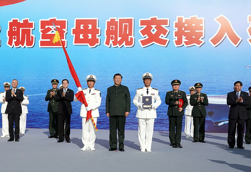 12月17日，我國第一艘國產(chǎn)航空母艦山東艦在海南三亞某軍港交付海軍。中共中央總書記、國家主席、中央軍委主席習近平出席交接入列儀式並登艦視察。這是習近平向海軍接艦部隊授予軍旗、命名証書。 新華社記者 李剛 攝