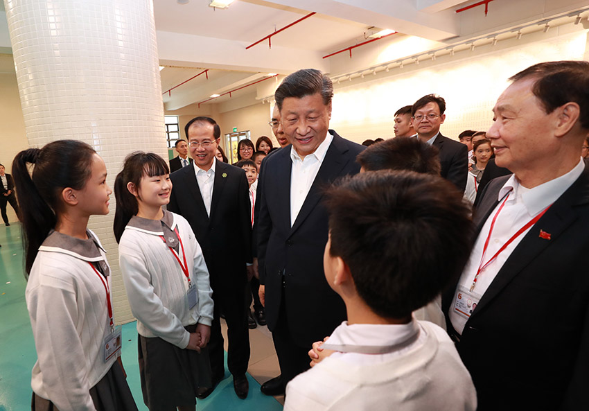 12月19日，國家主席習近平在澳門特別行政區(qū)行政長官崔世安陪同下，來到位於澳門黑沙環(huán)的政府綜合服務中心和濠江中學附屬英才學校，同澳門市民和師生親切交流。離開濠江中學附屬英才學校時，師生們圍攏過來，向習近平主席熱情問好。 新華社記者 龐興雷 攝